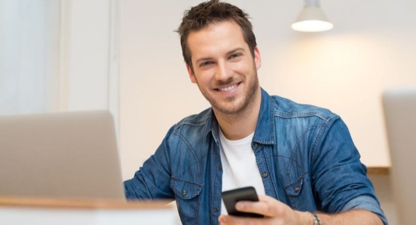 colaborador feliz segurando celular - novembro azul na empresa