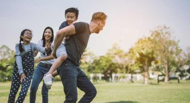 família feliz correndo no campo - dia da família na empresa