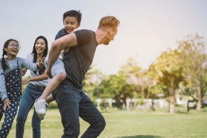 família feliz correndo no campo - dia da família na empresa