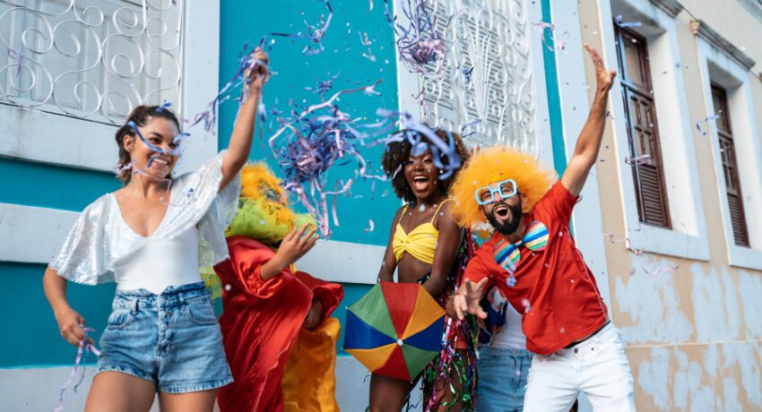 Carnaval 2026 — Ativações e brindes promocionais que fazem sucesso. Grupo de amigos fantasiados comemorando o Carnaval nas ruas. A folia continua com a sua marca junto, pensando nos brindes para eventos em 2026