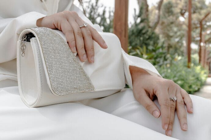 Mulher segurando clutch sofisticada em ambiente elegante que representa estilo de vida exclusivo e morar com sofisticação